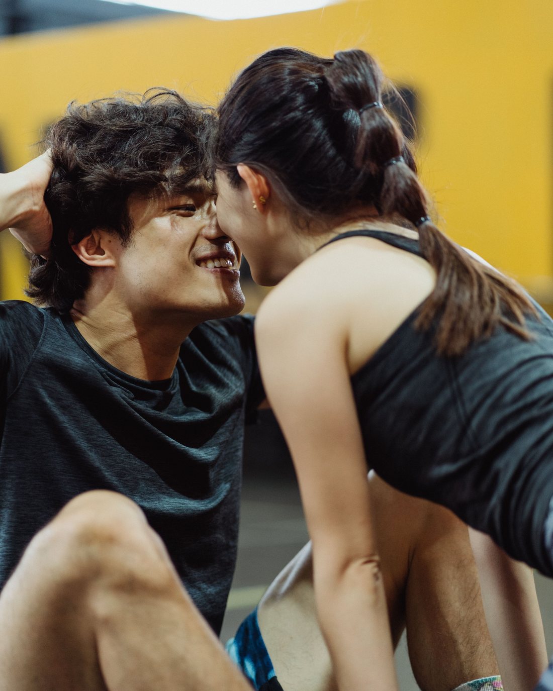 A couple face to face on the gym floor between sets